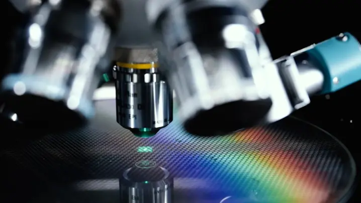 Close-up of a Polytec microscope objective capturing precise 3D surface roughness measurements with rainbow light reflection.